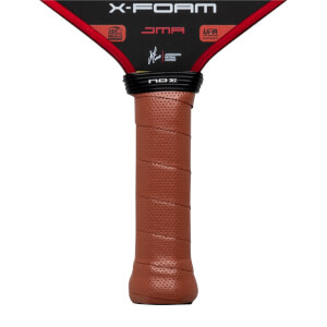 Close-up of the brown perforated handle and black neck featuring the NOX logo, with X-FOAM and JMA text visible on the black and red lower face of the paddle.