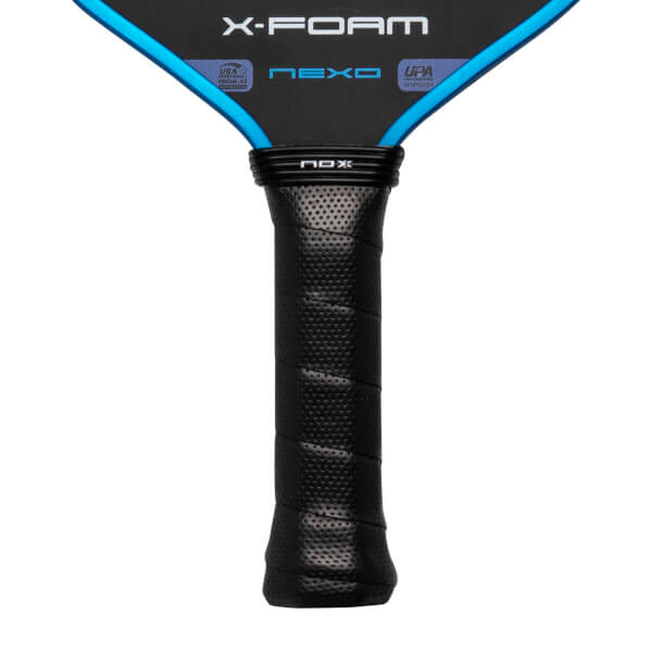 Close-up of the black perforated handle and lower paddle face featuring blue trim and labels for X-FOAM, NEXO, USA Pickleball, and UPA PRO.
