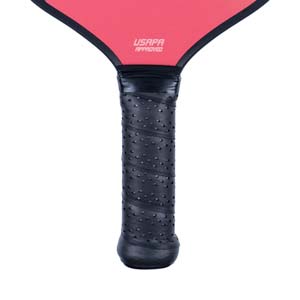 Close-up of a black pickleball paddle grip with a textured surface and USAPA APPROVED text.