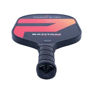Top-down view of a black pickleball paddle with a red and orange graphic, BANTAM EX-L PRO text, and a perforated grip.