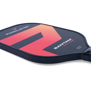 Corner view of a black pickleball paddle with a red and orange gradient graphic, BANTAM EX-L PRO text, and USAPA APPROVED stamp.