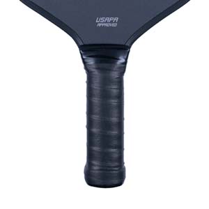 Close-up of a black pickleball paddle grip with USAPA APPROVED text on the paddle head.