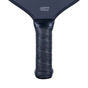 Close-up of a black pickleball paddle grip with a perforated texture and USAPA APPROVED text.