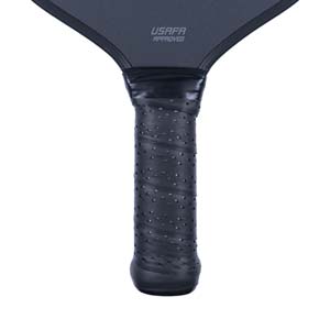 Close-up of a black pickleball paddle grip with a textured surface and USAPA APPROVED text.