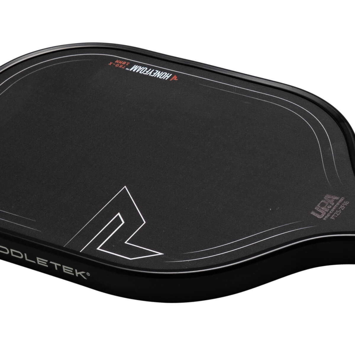 Corner view of a black Paddletek paddle showing the "HONEYFOAM™ TKO-X 16MM" text and a white angular logo.