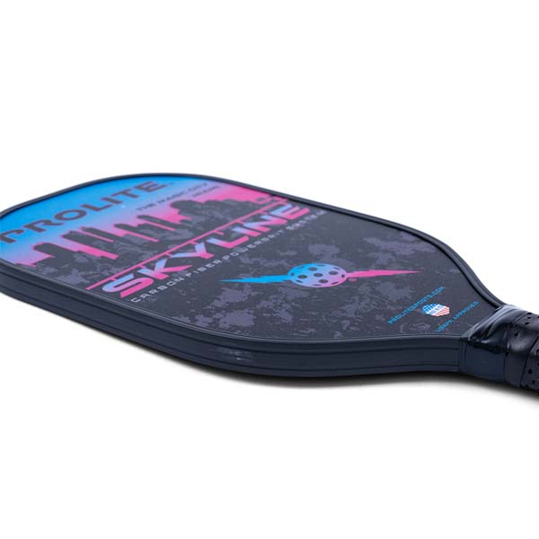 Side view of a dark blue PROLITE Skyline pickleball paddle with a cityscape graphic and pink/blue accents.