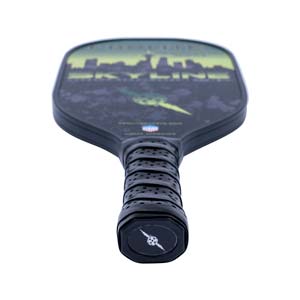 Top-down view of a black pickleball paddle with a skyline graphic and perforated grip.