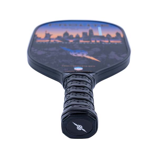 Top-down view of a black pickleball paddle with a city skyline graphic and perforated grip.