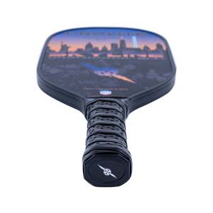Top-down view of a black pickleball paddle with a city skyline graphic and perforated grip.