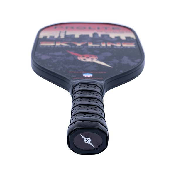 Top-down view of a black pickleball paddle with a skyline graphic and textured grip.