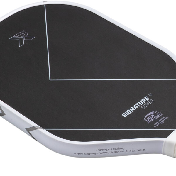 Angled close-up of a black and white pickleball paddle with ProXR logo, SIGNATURE SERIES text, and white lines.
