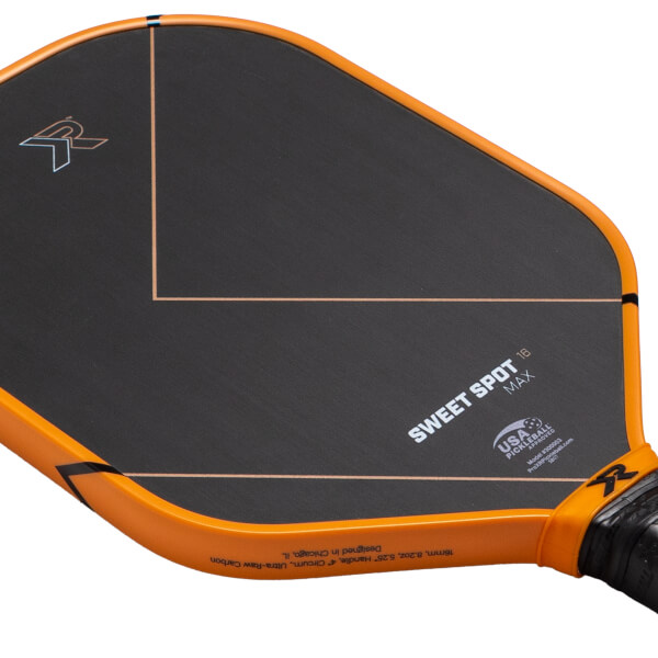 Angled close-up of a black and orange pickleball paddle with orange sweet spot lines, SWEET SPOT MAX text, and an R logo.