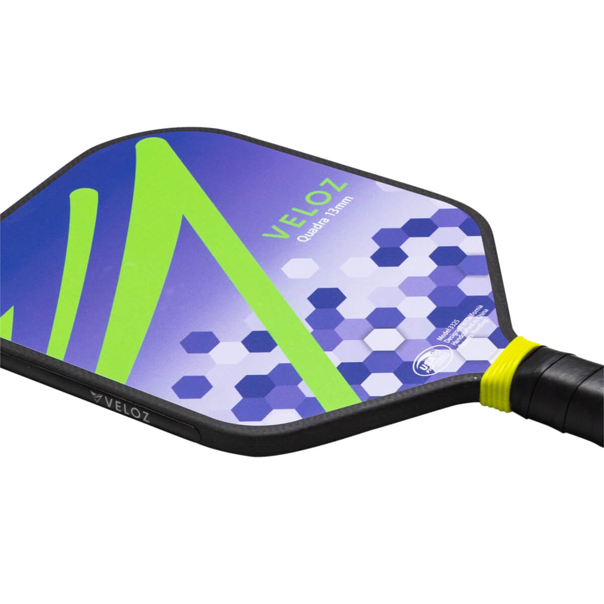Corner view of a pickleball paddle with a blue and purple hexagonal pattern, a lime green "V" shape, and "VELOZ" text.