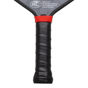 Close-up of the grip showing black textured wrap and a red band above it, with "USA PICKLEBALL APPROVED" visible.