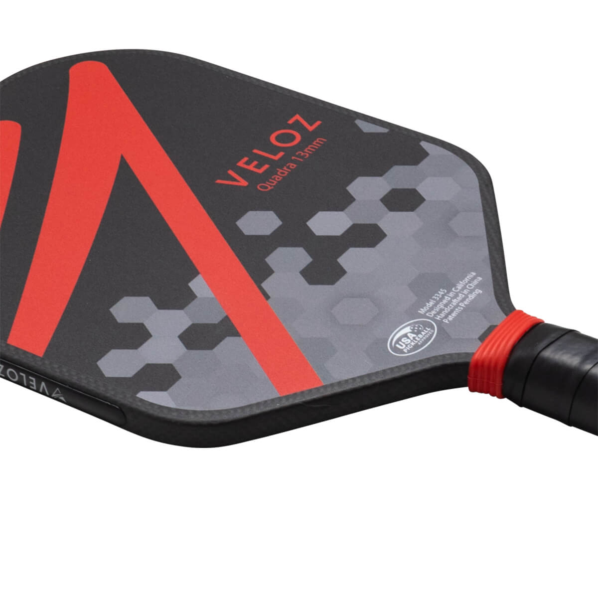 Corner view of the ProXR x Veloz Quadra 13mm paddle showing red V-shape graphic, hexagonal pattern, and "VELOZ" text.