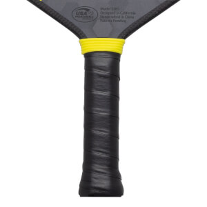 Close-up of a pickleball paddle grip with a yellow band and "USA PICKLEBALL APPROVED" text.