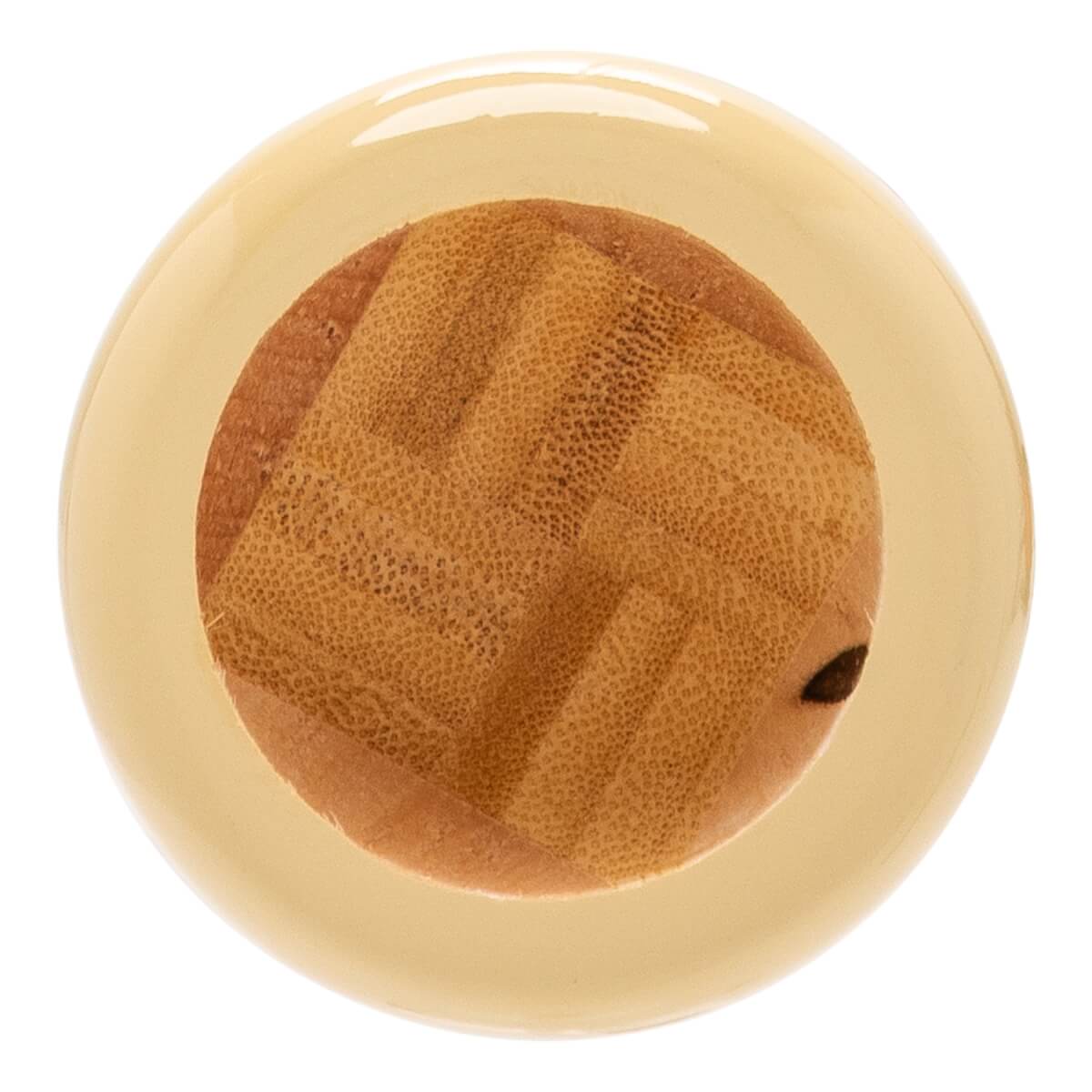 Top-down view of the glossy light beige end of a baseball bat, revealing a textured natural wood core with a small dark hole.