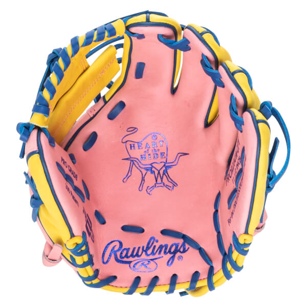 Top-down view of a pink baseball glove with yellow and blue lacing, featuring the Rawlings logo and "Heart of the Hide" emblem.