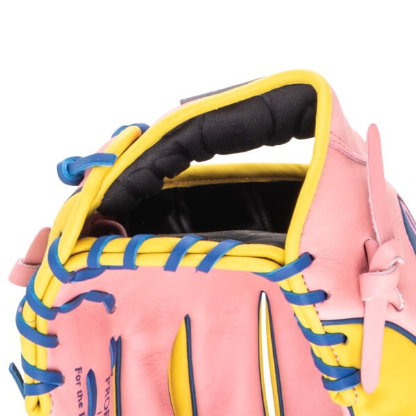Close-up of a pink baseball glove with yellow and blue lacing, showing the words "For the P" and "PROF".