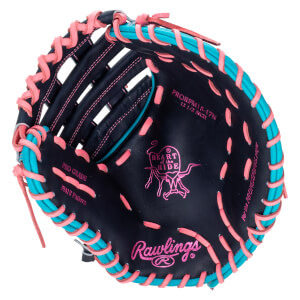 Top-down view of a black baseball glove with pink and teal lacing, featuring "Rawlings" and "Heart of the Hide" logos.