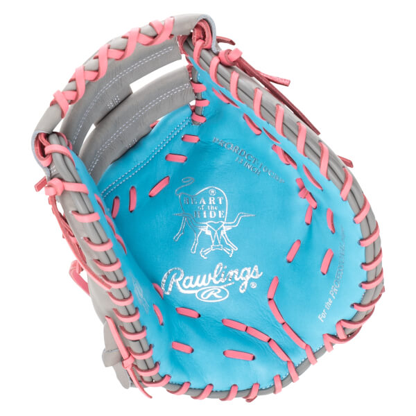 Interior view of a blue Rawlings glove with pink lacing and "HEART of the HIDE" logo.