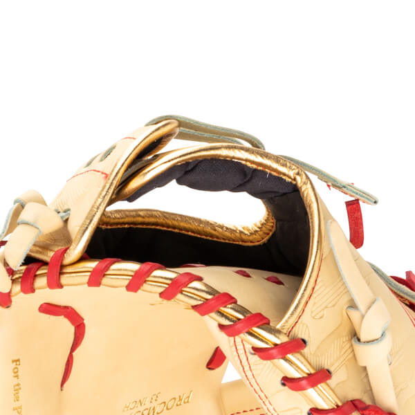 Close-up of a baseball glove showing gold trim, red lacing, and embossed patterns.