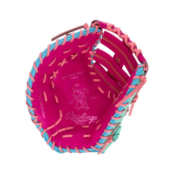 Front view of a pink 13-inch first base mitt with light blue and pink laces, featuring "Rawlings" and "Heart of the Hide" branding stamped on the palm.