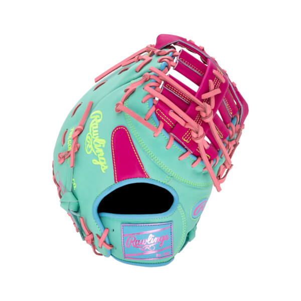 Back view of a mint green first base mitt with pink and light blue accents, pink laces, and the yellow "Rawlings" script logo and "Est. 1887" patch.