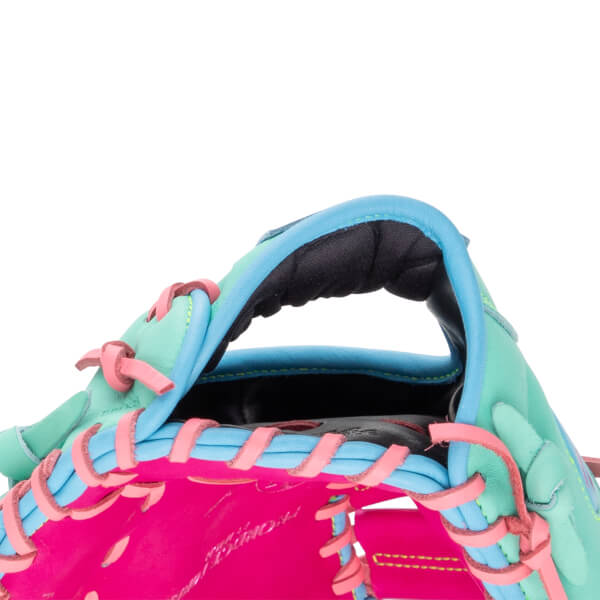 Close-up of the wrist opening features teal and bright pink leather with blue trim, pink laces, and a black padded interior with "Rawlings" script on the palm.