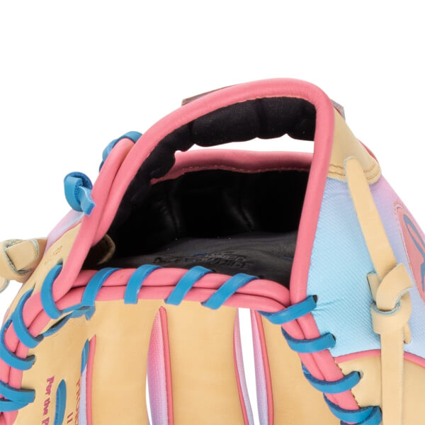Close-up of a baseball glove's interior showing pink and blue lacing, a black palm with embossed text, and pastel panels.