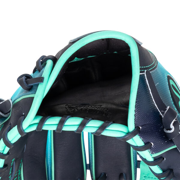 Close-up of the inside of a baseball glove showing the black leather palm with "TANNED COWHIDE" embossed and teal lacing.