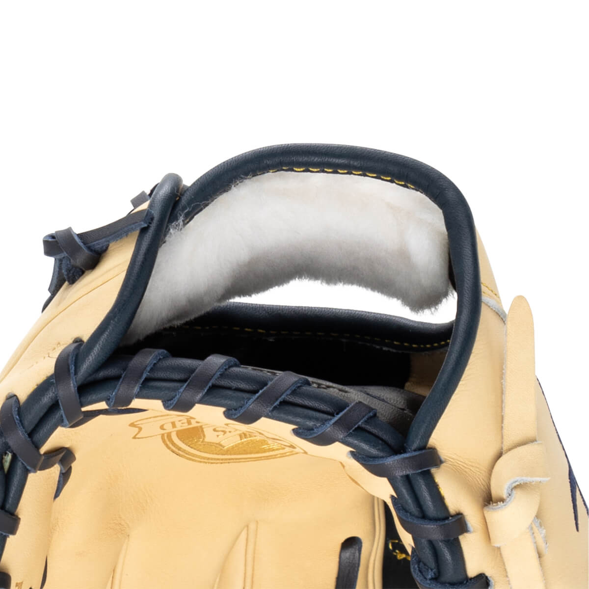 Close-up of a tan baseball glove's interior, showing white lining and navy lacing.