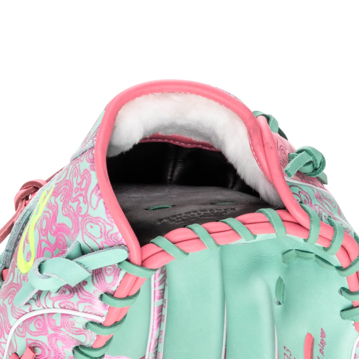 Close-up of the inside of a baseball glove, showing white padding, pink trim, and a teal exterior with a pink swirl pattern.
