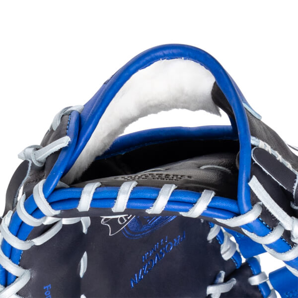 Close-up of the top of a navy baseball glove with blue lacing and white trim. "PROSCVN" is visible.
