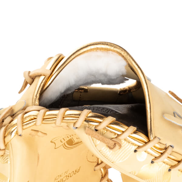 Close-up of the inside of a gold baseball glove showing white lining and tan lacing.