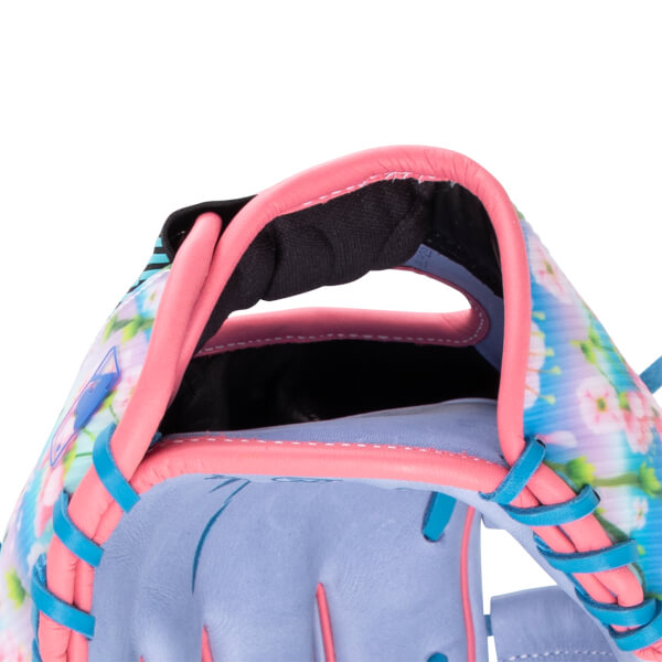 Close-up view of a baseball glove showing pink binding, blue lacing, and a floral pattern.