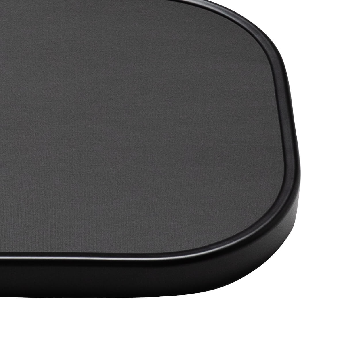 Corner view of a black textured surface with a smooth, rounded edge.