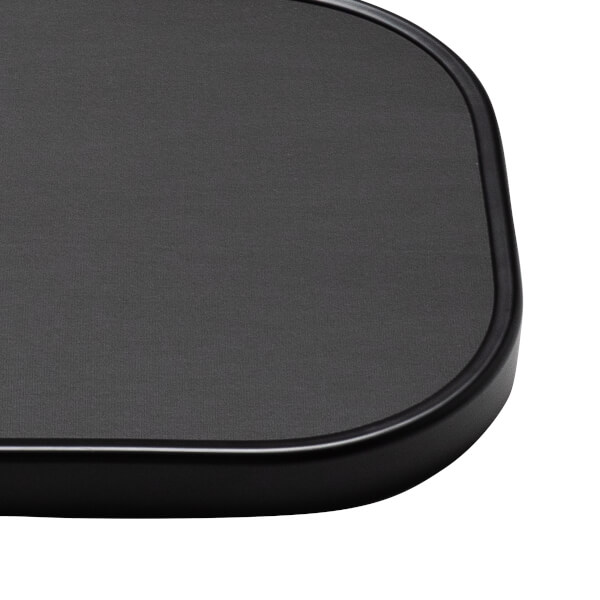 Corner view of a black textured surface with a smooth, rounded edge.