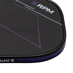 Close-up corner view of a black paddle featuring a white RPM logo, purple geometric lines, and a purple protective edge guard.