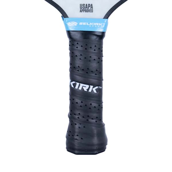 Close-up of a black pickleball paddle grip with KIRK logo and blue Selkirk branding.