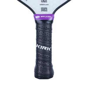 Close-up of a black pickleball paddle grip with a purple band and white KIRK text.