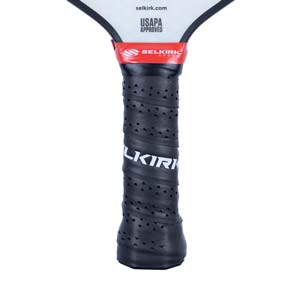 Close-up of a black pickleball paddle grip with perforations and white SELKIRK text.