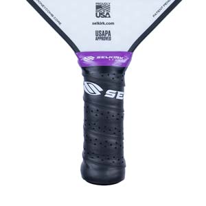 Close-up of a black pickleball paddle grip with purple Selkirk branding and USAPA approved logo.