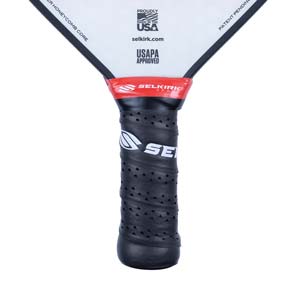 Close-up of a black pickleball paddle grip with a Selkirk logo and USAPA approved text.