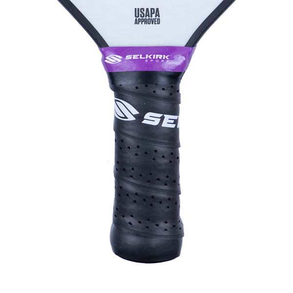 Close-up of a black pickleball paddle grip with purple Selkirk Sport branding and USAPA Approved text.