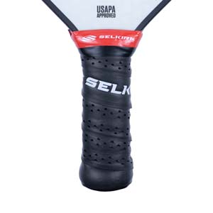 Close-up of a black pickleball paddle grip with white SELKIRK text and red Selkirk branding.