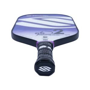 Top-down view of a purple and white pickleball paddle with a black grip and S2 branding.