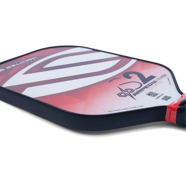 Side view of a red and white Selkirk Amped S2 pickleball paddle with S2 graphic and Polymer Honeycomb Core text.