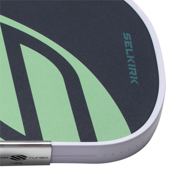 Close-up of a dark gray pickleball paddle with a light green abstract design, SELKIRK branding, and a white edge guard.