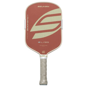 Front view of a red pickleball paddle with a beige border, featuring a large S-shaped design and "SELKIRK" logo.